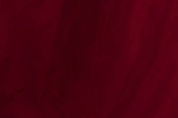 Photo of Abstract background of dark red-maroon colour to a milk mixture.