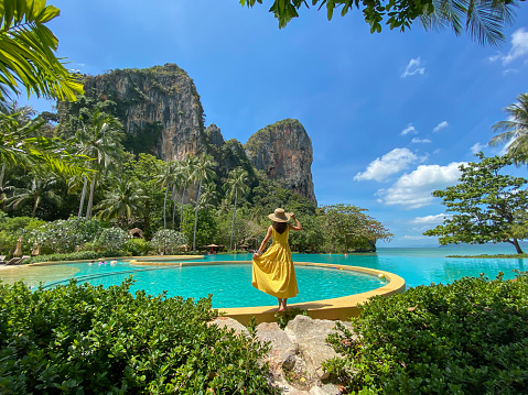 Woman tourist in yellow dress and hat traveling on Railay beach, Krabi, Thailand. vacation, travel, summer, Wanderlust and holiday concept