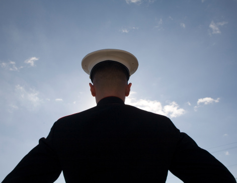 silhouette of a U.S. Marine with a blue sky and a few clouds