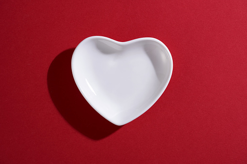 small heart shape saucer or bowl on red background