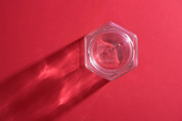 top view of empty honey jar against red background