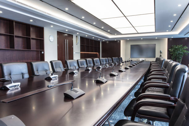 豪華な会議室に快適な革張りの椅子ときれいに配置されたマイク - 株主総会 ストックフォトと画像