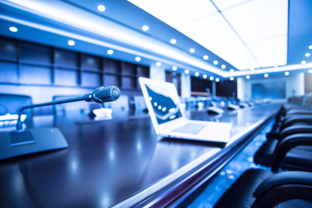 istock Isolated view of a microphone and  computer in the front of a conference room 1404776426