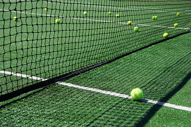 istock tennis balls besides a net 140477702