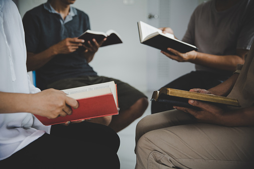 Group of people are reading the bible. soft focus, praying and praise together at home. devotional or prayer meeting concept.