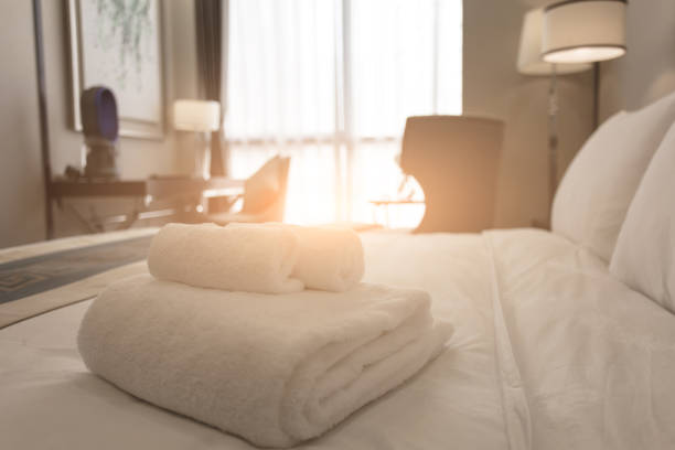 toallas de baño blancas limpias en el dormitorio perfectamente limpio - comodidad y concepto limpio - hotel room bedding domestic room hotel suite fotografías e imágenes de stock
