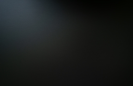 La textura de la losa de carbono negro oscuro se ilumina desde la parte superior. photo