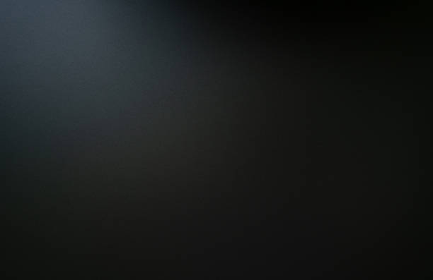 The texture of the dark black carbon slab is illuminated from the top.