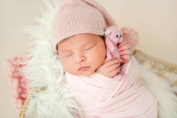 istock newborn baby sleeping with a small toy 1404796016