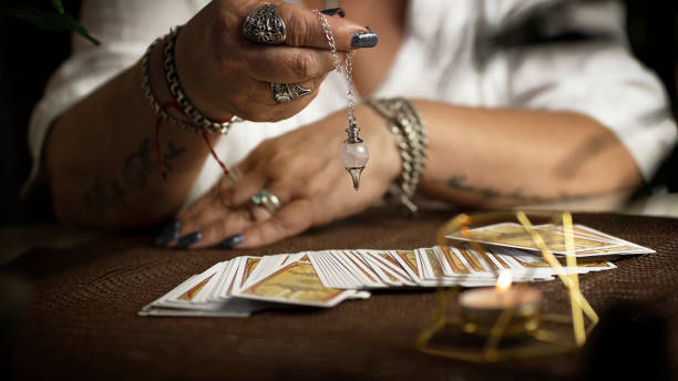 Defocused still Life with tarot cards. magic or fortune telling rite with occult and esoteric symbols. Tarot cards on wooden table. Fortune teller table. tarragon horizontal color image photography stock pictures, royalty-free photos & images