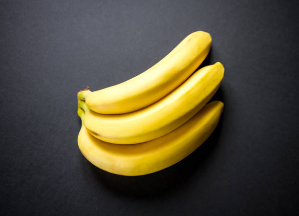 istock Bunch of bananas isolated on black background 1404799414