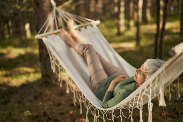istock Relaxed senior woman taking a nap in hammock. 1404799849