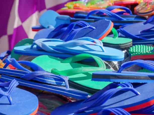 Photo of pile of slippers at street stall. Slippers also called as hawai chappal in India.