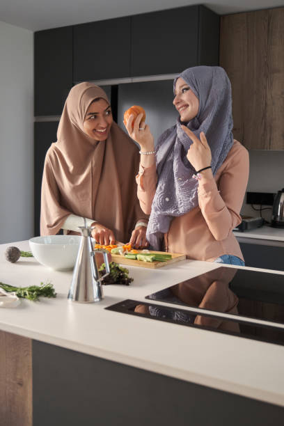 istock Two muslim women preparing a salad at modern kitchen. 1404804574