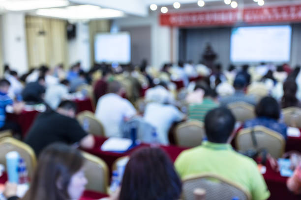 Education concept, Abstract blurred background image of students and business people studying and discuss in large hall profession seminar with screen