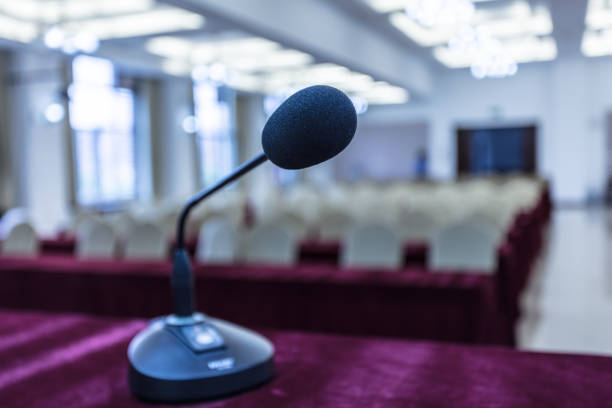 istock Microphone in front of podium with chairs in the background 1404806273