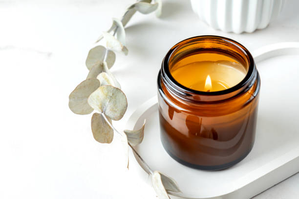 istock Brown burning candle on woolen table and eucalyptus branch at home in cozy atmosphere 1404806334
