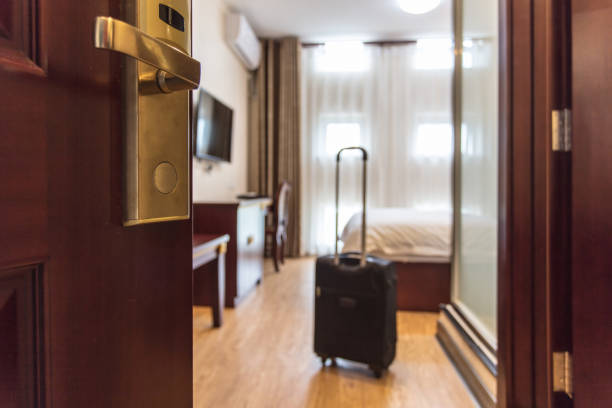 スーツケースはホテルの部屋に立って配達しました。ホテルサービスと旅行のコンセプト