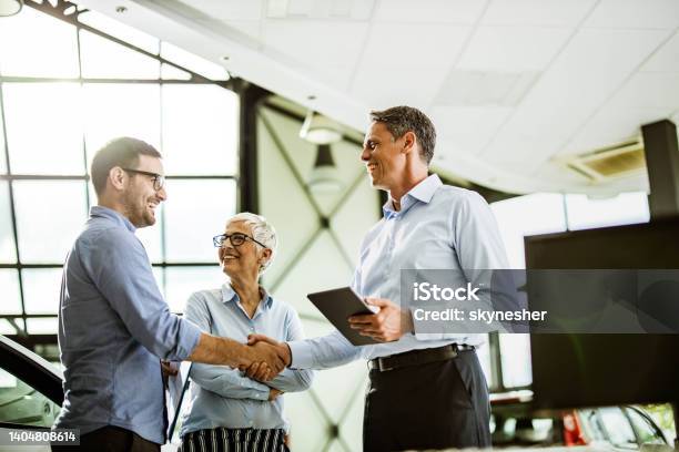 Business Colleagues Came To An Agreement With Car Salesperson In A Showroom Stock Photo - Download Image Now
