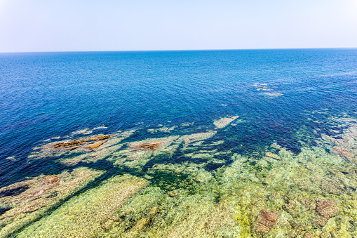 Aerial view of rocks on the sea. Overview of the seabed seen from above, transparent water