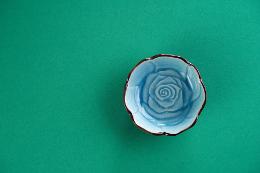 small rose pattern saucer or bowl on green background