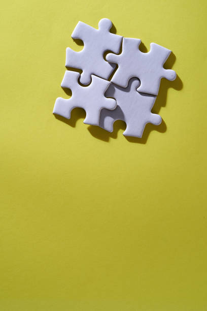 4 pieces of white blank jigsaw puzzle on yellow background