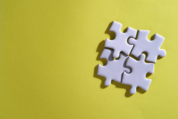 istock 4 pieces of white blank jigsaw puzzle on yellow background 1404810018