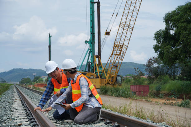 2 asian engineers working outside for checking the build a high-speed railway.