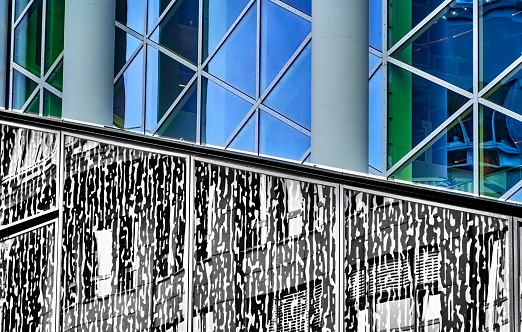 Cutout of a mirrored glass facade with triangle pattern and blue reflections, abstract