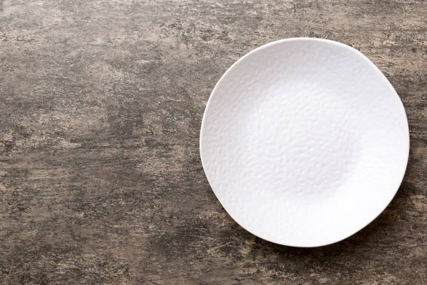 istock Top view of empty light plate on cement background. Empty space for your design 1404814717