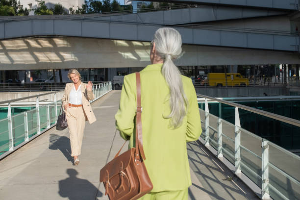 istock Woman greeting her friend in downtown area while going at work 1404818067