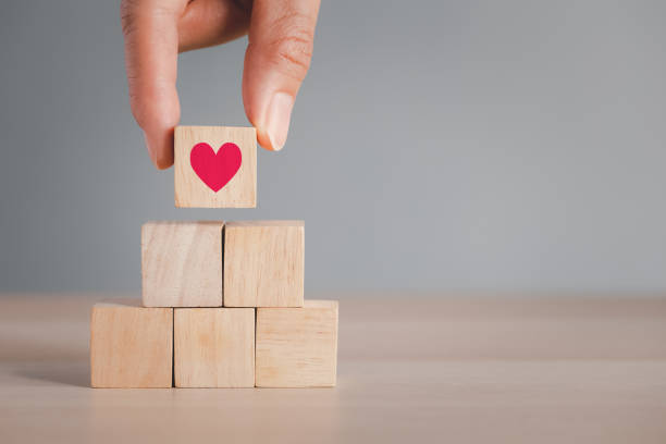 istock fingers picking top wood cube arranged on wood table 1404819393