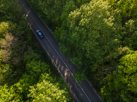 Car on road in the forest in summer time nature from air . View from a drone. Aerial view.