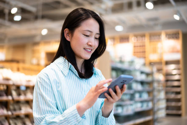 istock Asian young woman using smartphone in shopping mall 1404820714