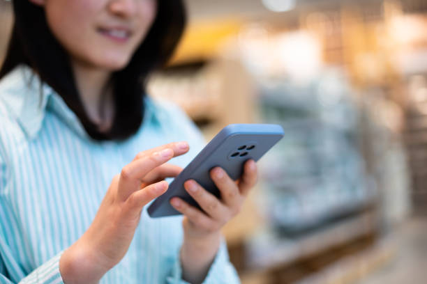 istock Asian young woman using smartphone in shopping mall 1404820722