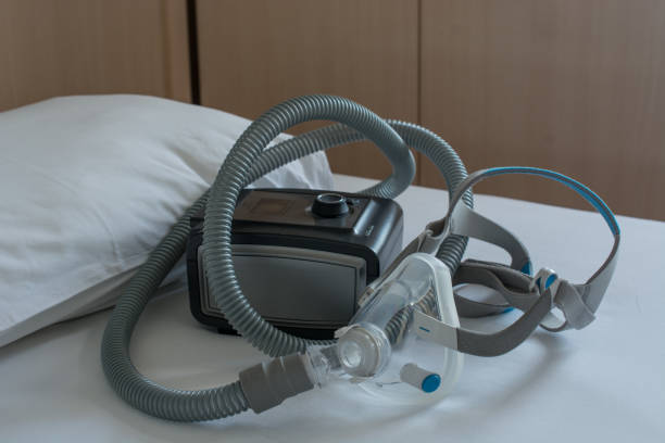 máquina cpap con manguera de aire y máscara de cabeza - apnea del sueño fotografías e imágenes de stock
