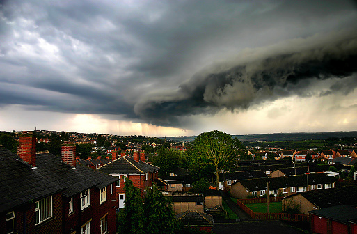 Large storm cloud over a small town in the UK with red brick houses