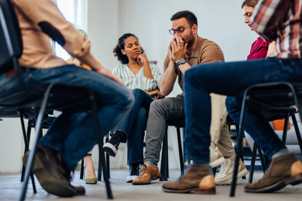 istock Bottom view of a man holding his tears back, looking emotional, having group therapy. 1404821380