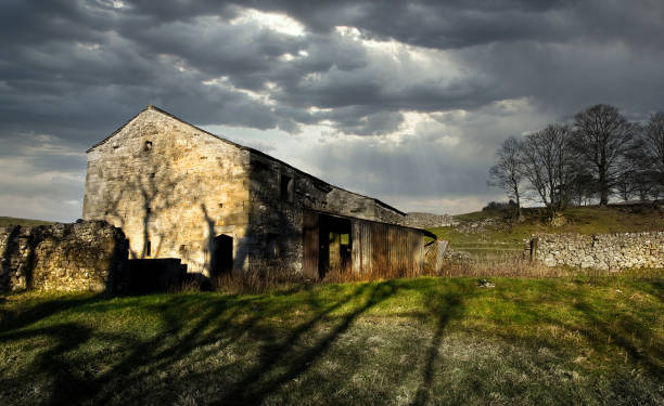 Rural Stone Building in the Yorkshire Dales Rural Stone Building in the Yorkshire Dales with stormy sky's and sun lit building country road sky field cloudscape stock pictures, royalty-free photos & images
