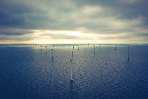 Aerial drone shot of of coastal wind turbines at the Rødsand wind farm situated in southern Denmark. The wind park comprises 90 wind mills with a total capacity of 215 MW.  Green energy is the hot alternative to fossil fuel and the world is now preparing for this transition. Images shot with drone