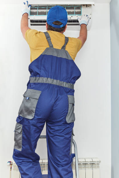 istock Repairman cleaning and fixing indoors AC unit. 1404822584