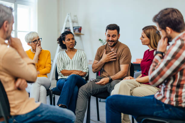 An upset man told his problems, looking emotional during the group therapy. stock photo