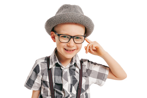 Looking at camera. Portrait of cute little boy, happy kid in eyeglasses and hat isolated on white studio background with copyspace for ad. Concept of child emotions, facial expression, beauty and ad.