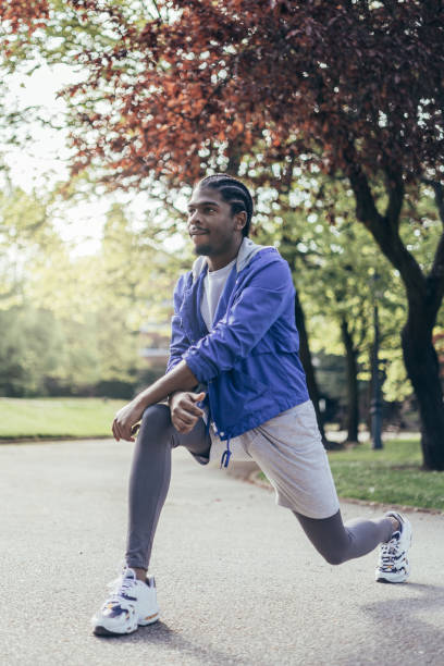 istock young african american man stretching quadriceps before running in park 1404825513