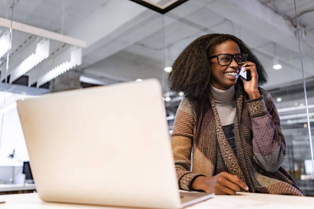 istock Happy black freelancer talking on cell phone in the office. 1404825870
