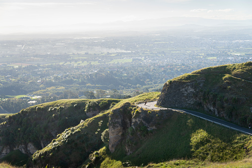 Panorama view of a cyclist riding down the winding road from Te Mata Peak, Hawke\