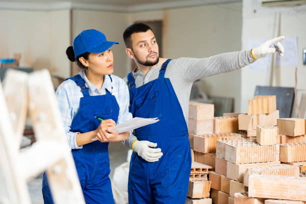 Woman and man repairers talking about documentation stock photo