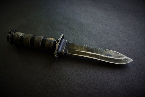 black military knife on black background