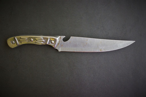 Folding knives on brown background. Selective focus.