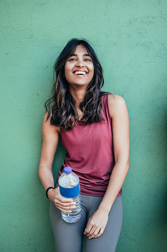 portrait of beautiful young indian woman resting and refreshing after running
